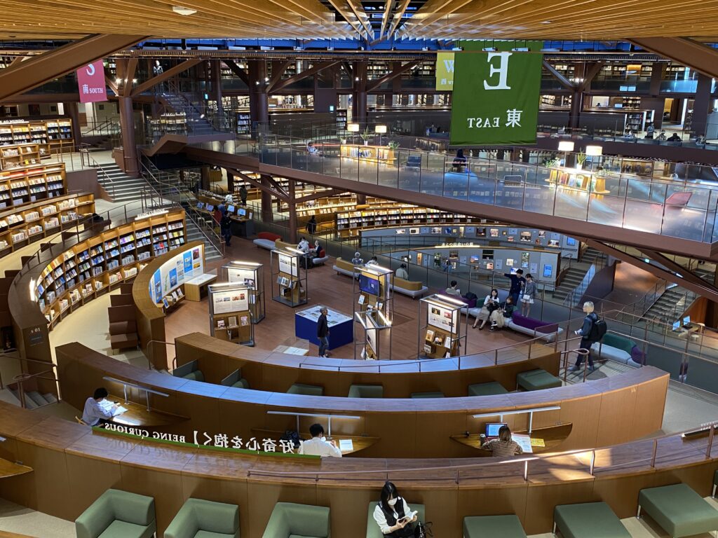 A circle of bookshelves and chairs behind them