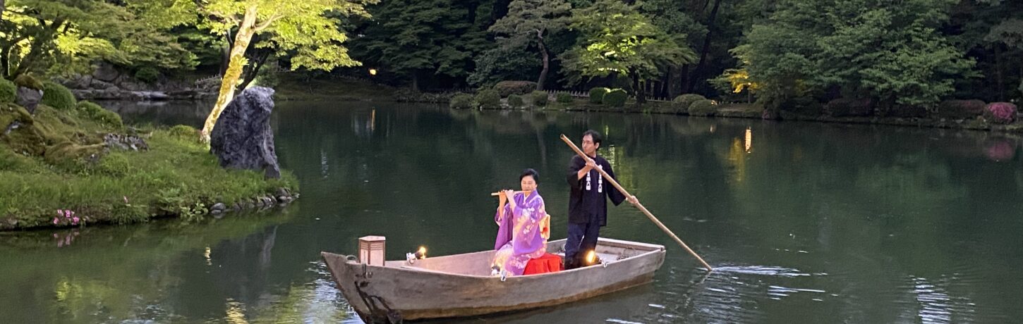 兼六園・霞ヶ池に浮かべた小舟の上で横笛を演奏する女性